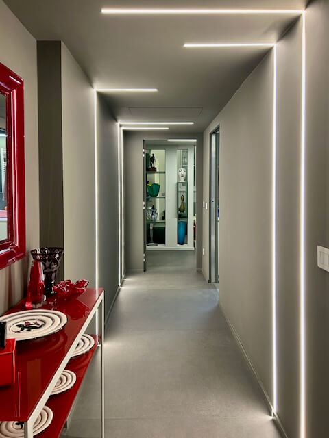 Il corridoio disegnato da linee di luce incassate che corrono su soffitto e pareti